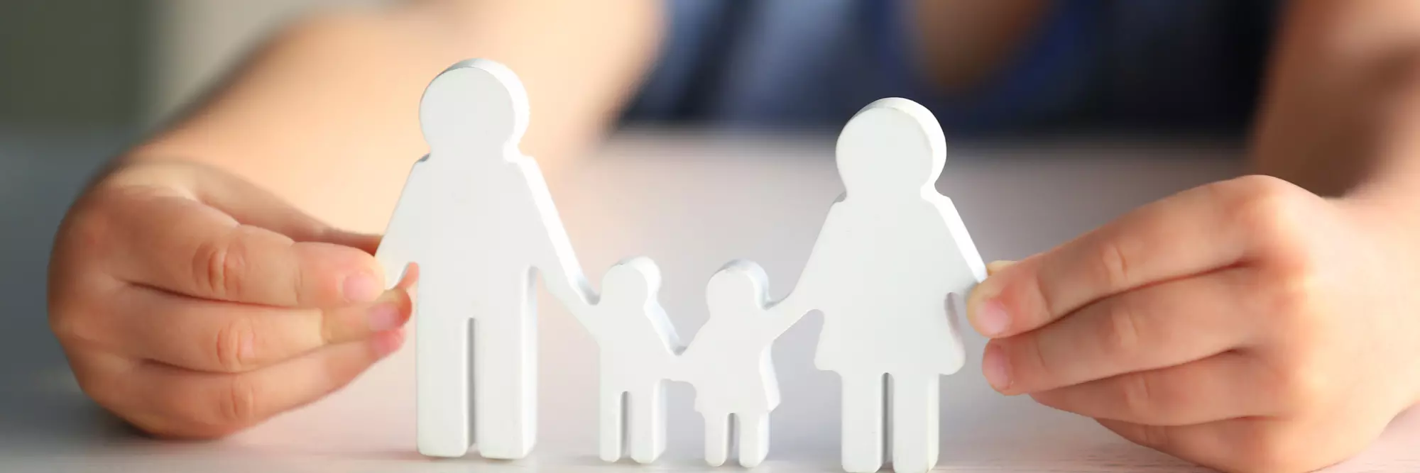 Diritto di famiglia. Quattro figure stilizzate di persone in legno, rappresentanti una famiglia, mentre si tengono per mano. L'immagine trasmette un senso di unità e affetto.