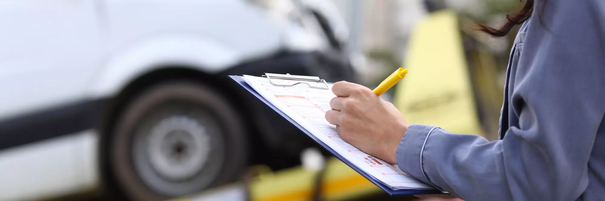 Responsabilità danni stradali. Un operatore tiene un clipboard con un modulo di valutazione mentre annota dettagli di un veicolo, sullo sfondo un'auto in riparazione. Un'illustrazione del lavoro di ispezione automobilistica.